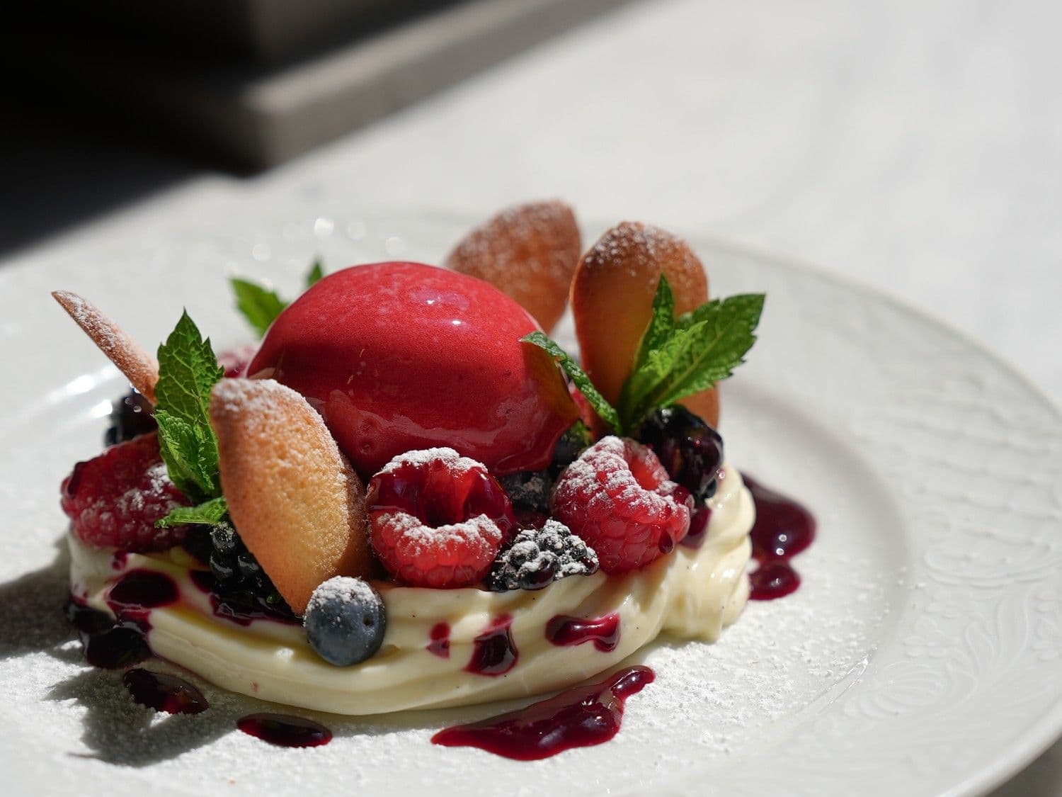 Ganache van witte chocolade met rood fruit, frambozensorbet en kattentongen