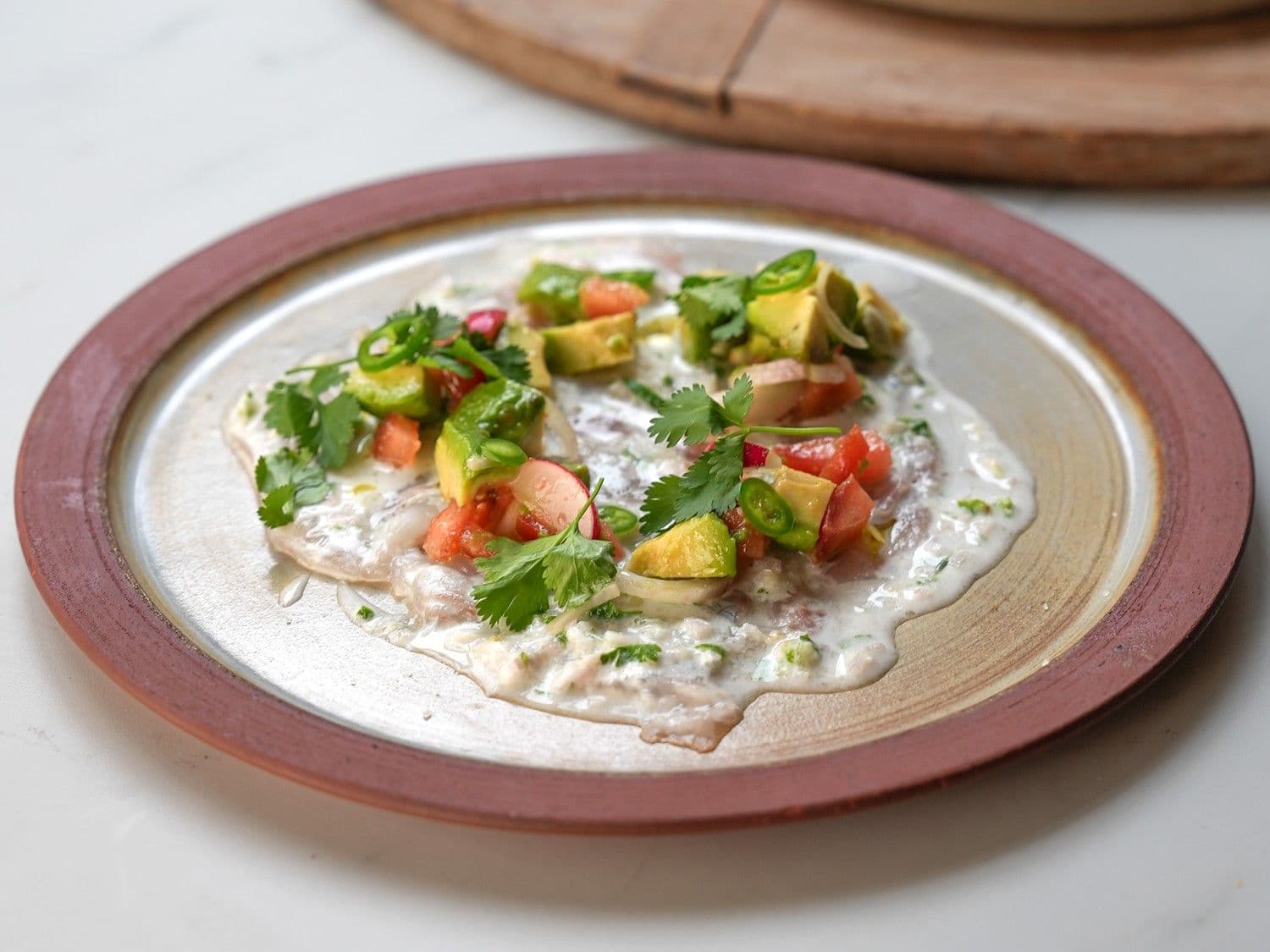 Carpaccio van zeebaars met leche del tigre en avocadosalsa