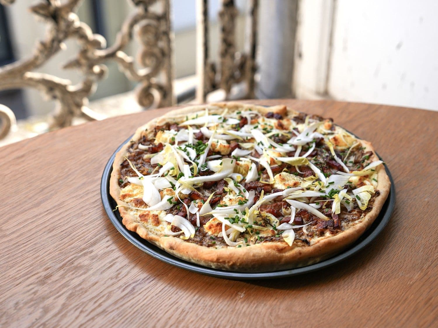 Tarte flambée met gekarameliseerd witloof, gerookt spek en geitenkaas