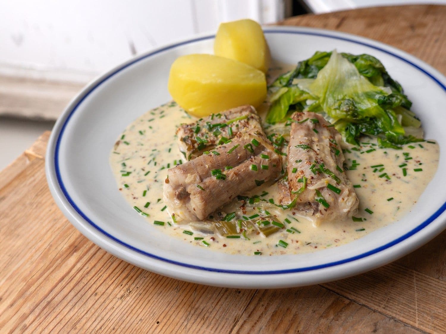 Hondshaai in mosterdsaus met andijvie en kasteelaardappelen