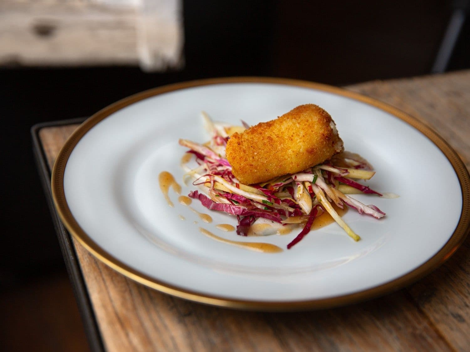 Kroket van geitenkaas en witloofsalade met radicchio en honingvinaigrette