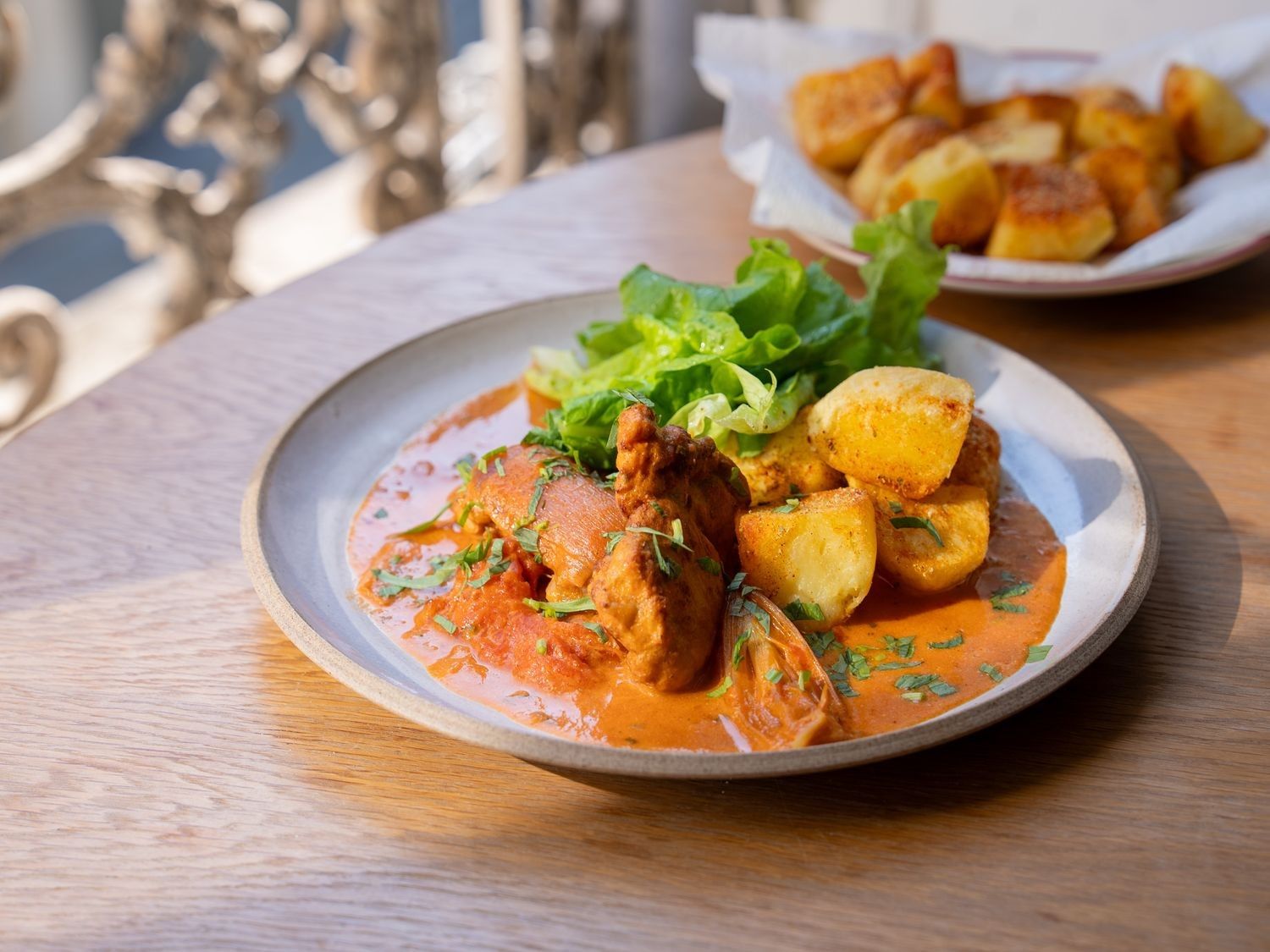 Kip in romige tomatensaus met gebakken aardappelen en sla