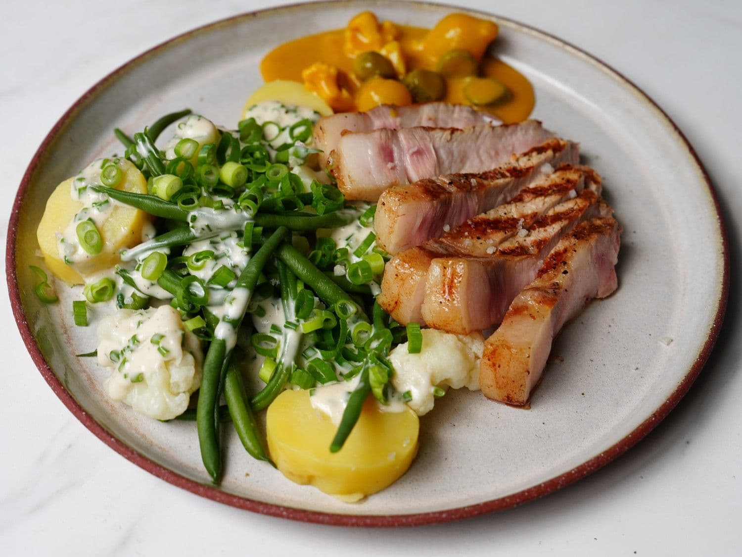Varkenskotelet met lauwe aardappel en verse pickles