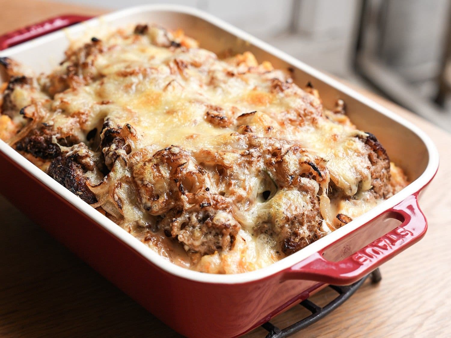 Ovenschotel met wortelpuree, gehakt, gebakken uien en gemalen kaas