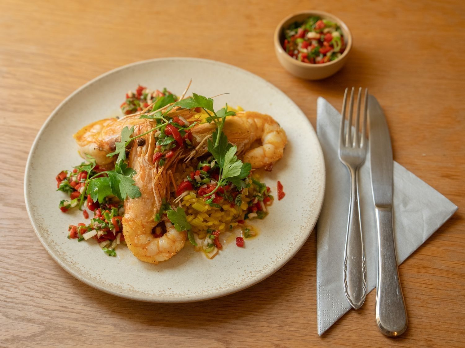 Gamba's met saffraanrijst en salsa van pimiento del piquillo