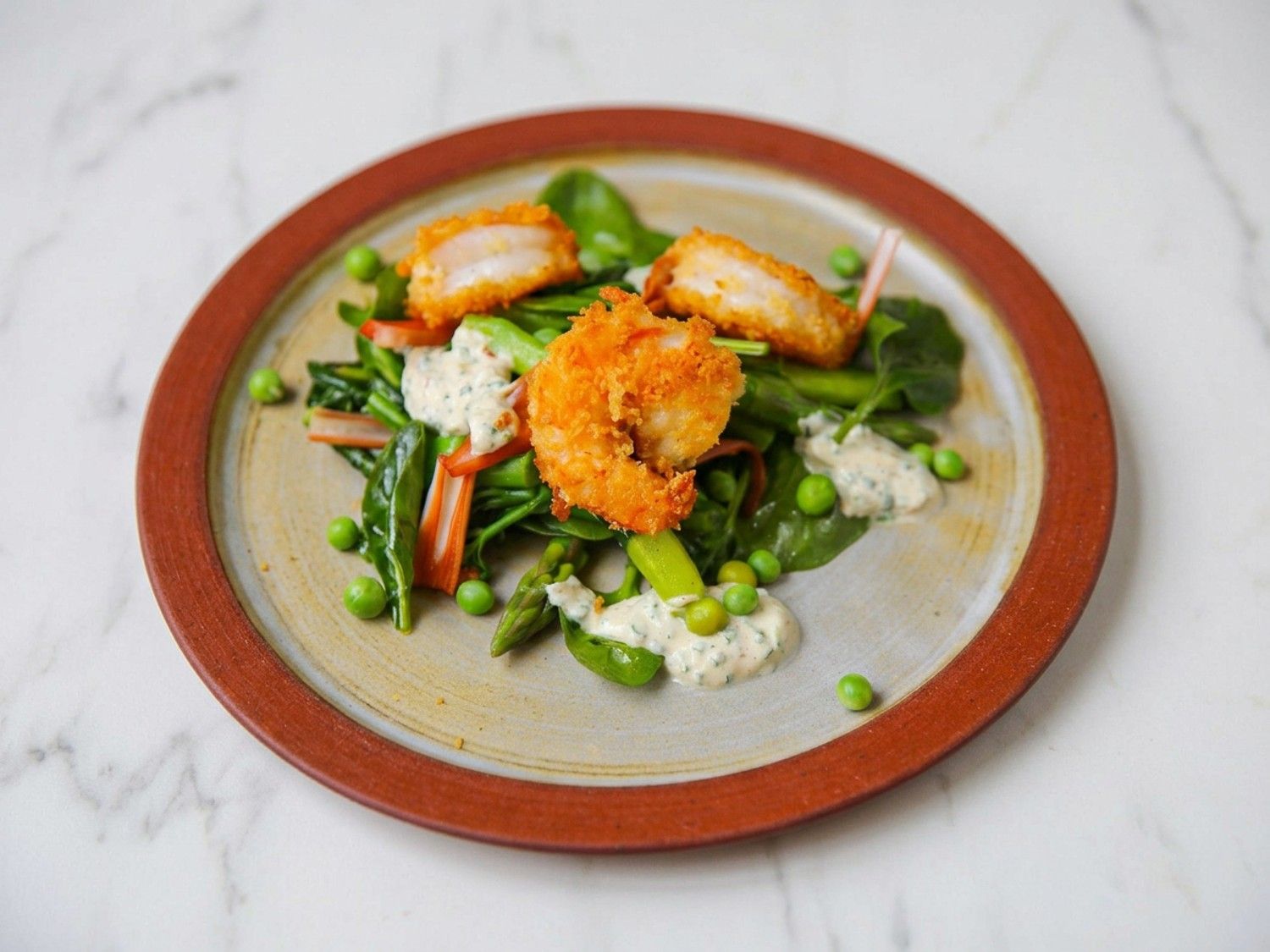 Groene salade met gepaneerde scampi's en dressing met citroen en look