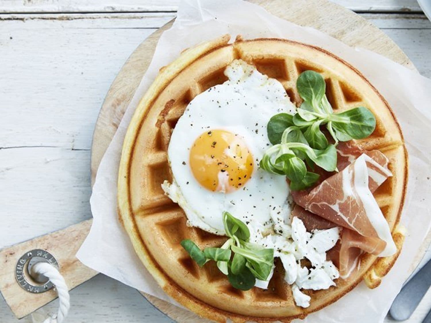 Ontbijtwafel met spiegeleitje, gedroogde ham en geitenkaas