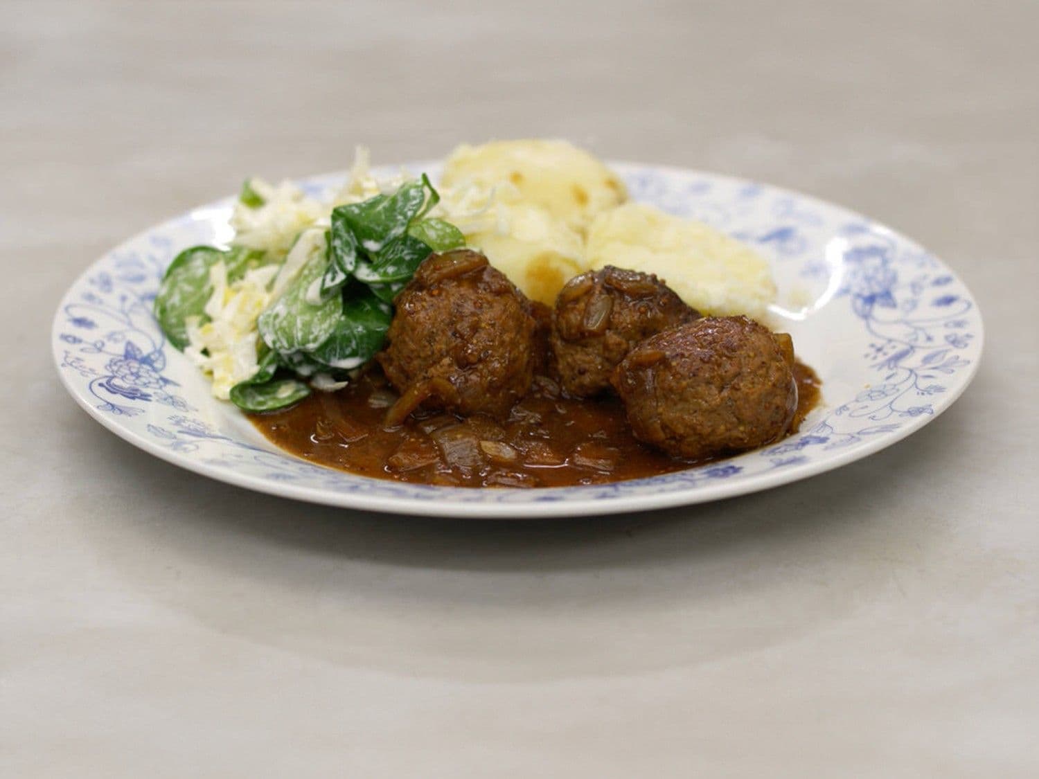 Gehaktballen in stout met veldsla, witloof en aardappelen