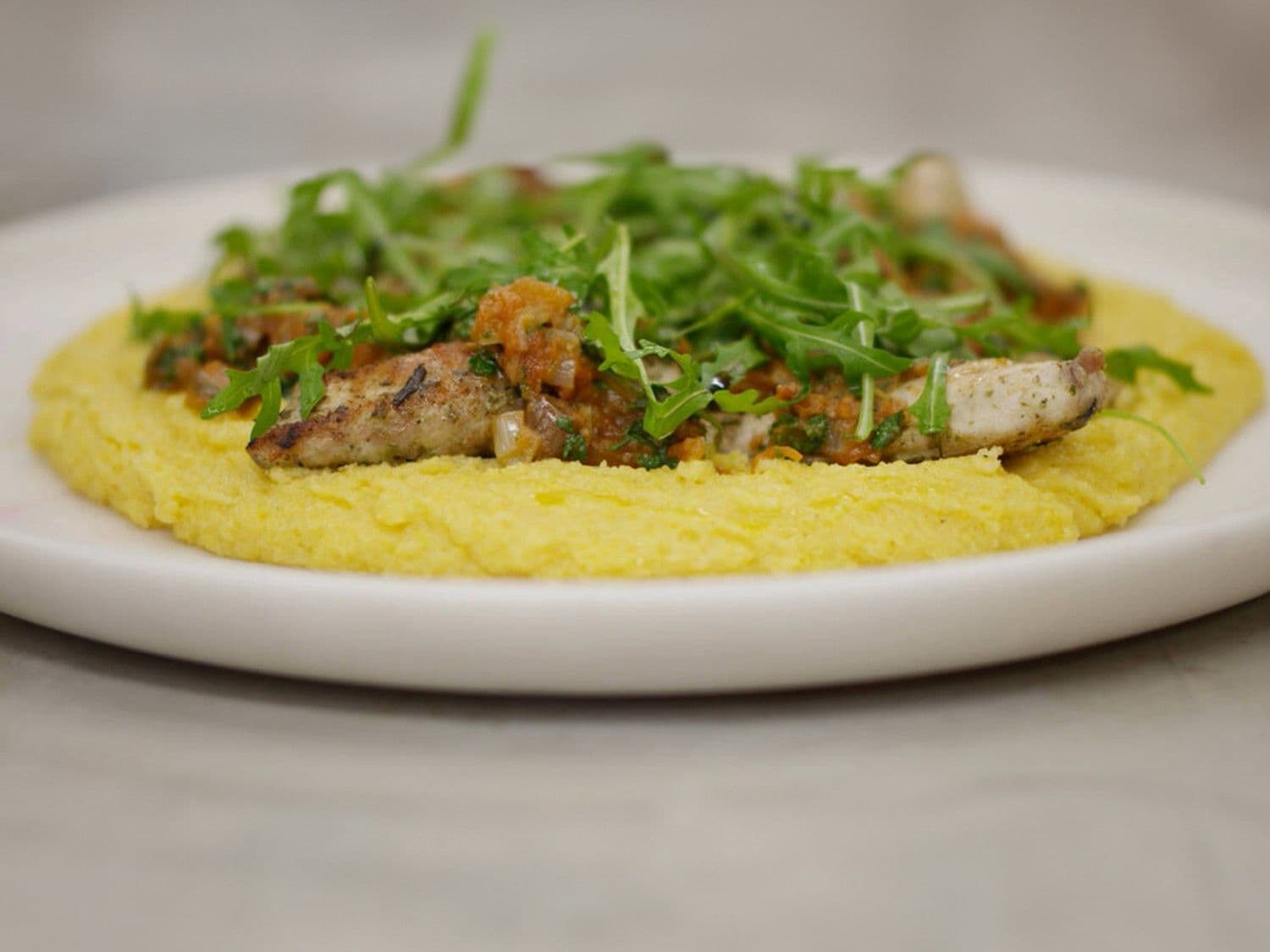 Gegrilde konijnfilets alla puttanesca met polenta en rucola