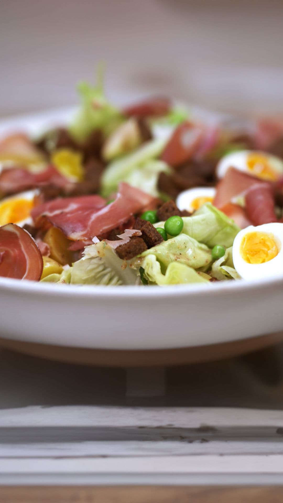 Salade met erwten, rauwe ham en croutons