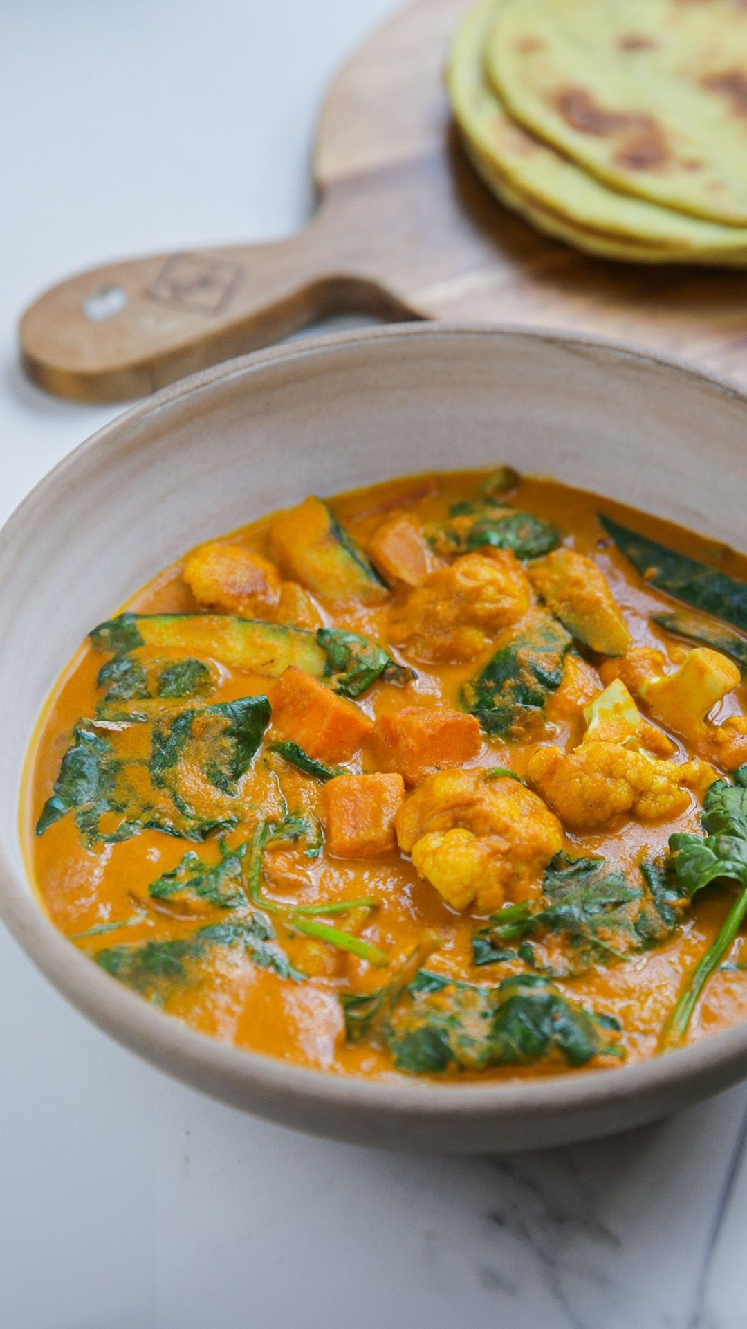 Curry van courgette, zoete aardappel en bloemkool met naan