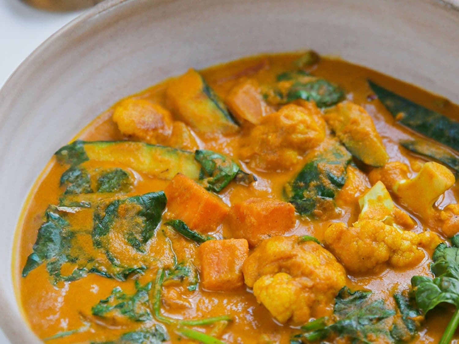 Curry van courgette, zoete aardappel en bloemkool met naan