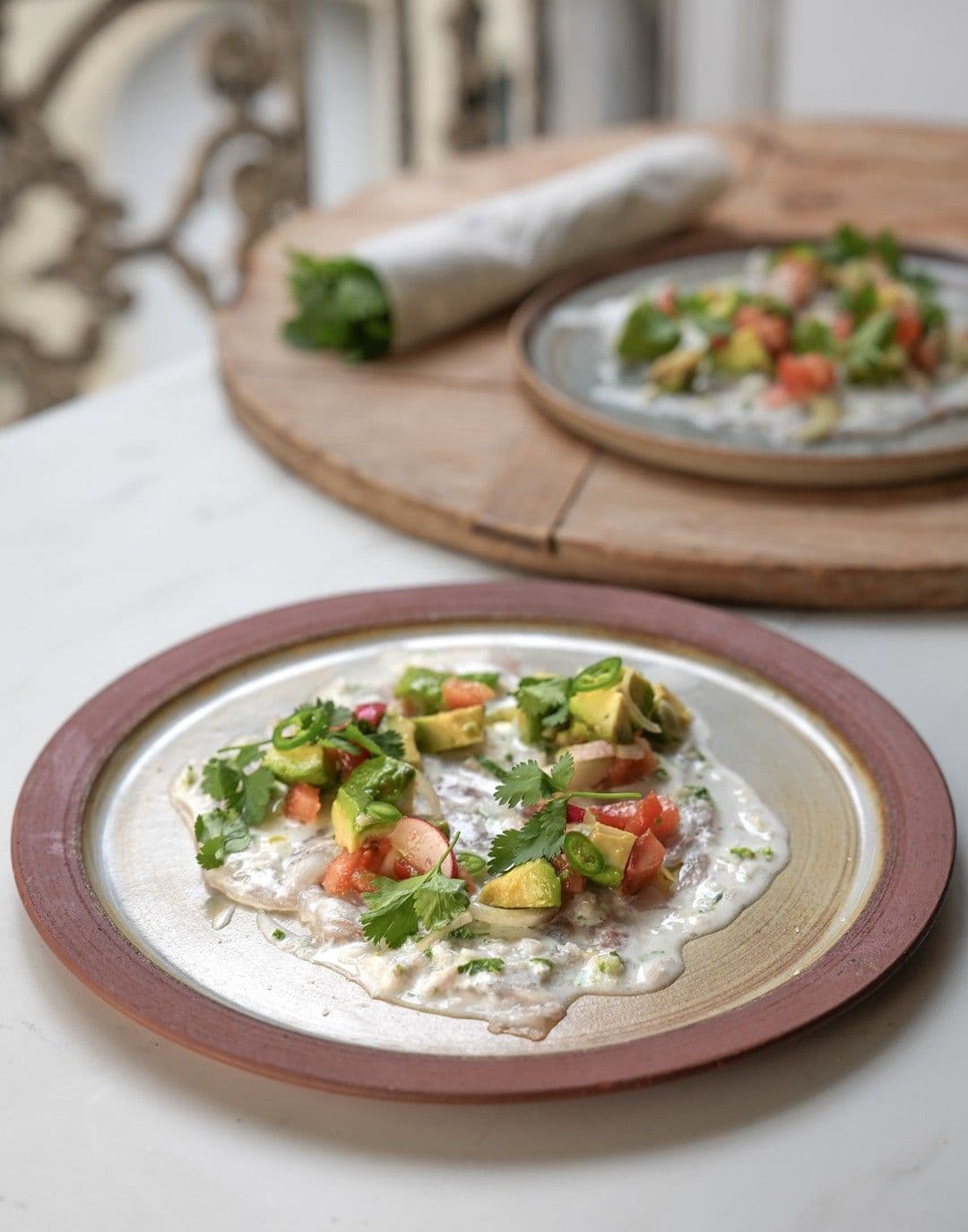 Carpaccio van zeebaars met leche del tigre en avocadosalsa