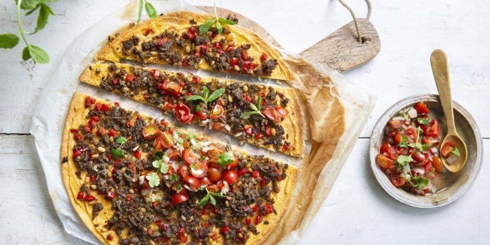 Pizza met kruidig gehakt, hummus en tomatensalsa