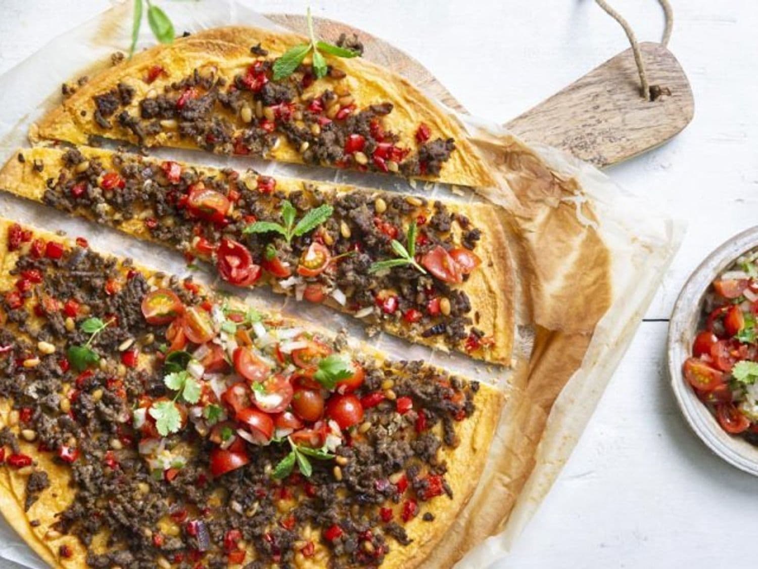 Pizza met kruidig gehakt, hummus en tomatensalsa