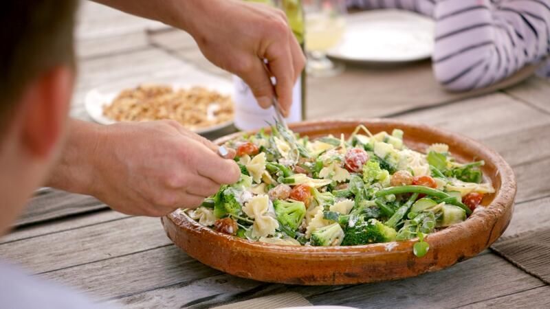 Vlinderpasta met boontjes, chipolata en currydressing
