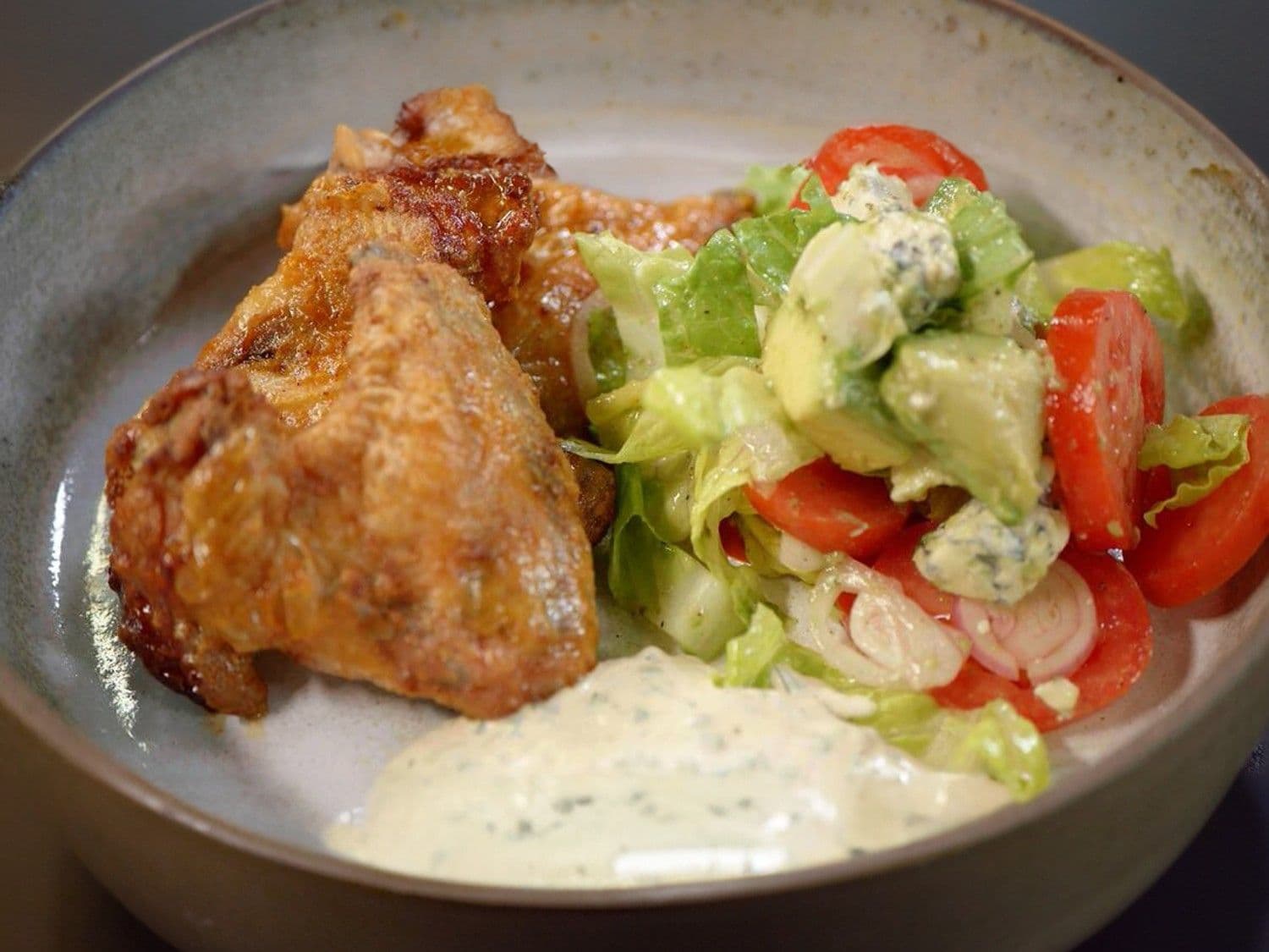 Pikante kippenvleugels, salade met blauwe kaas, avocado en ranch dressing