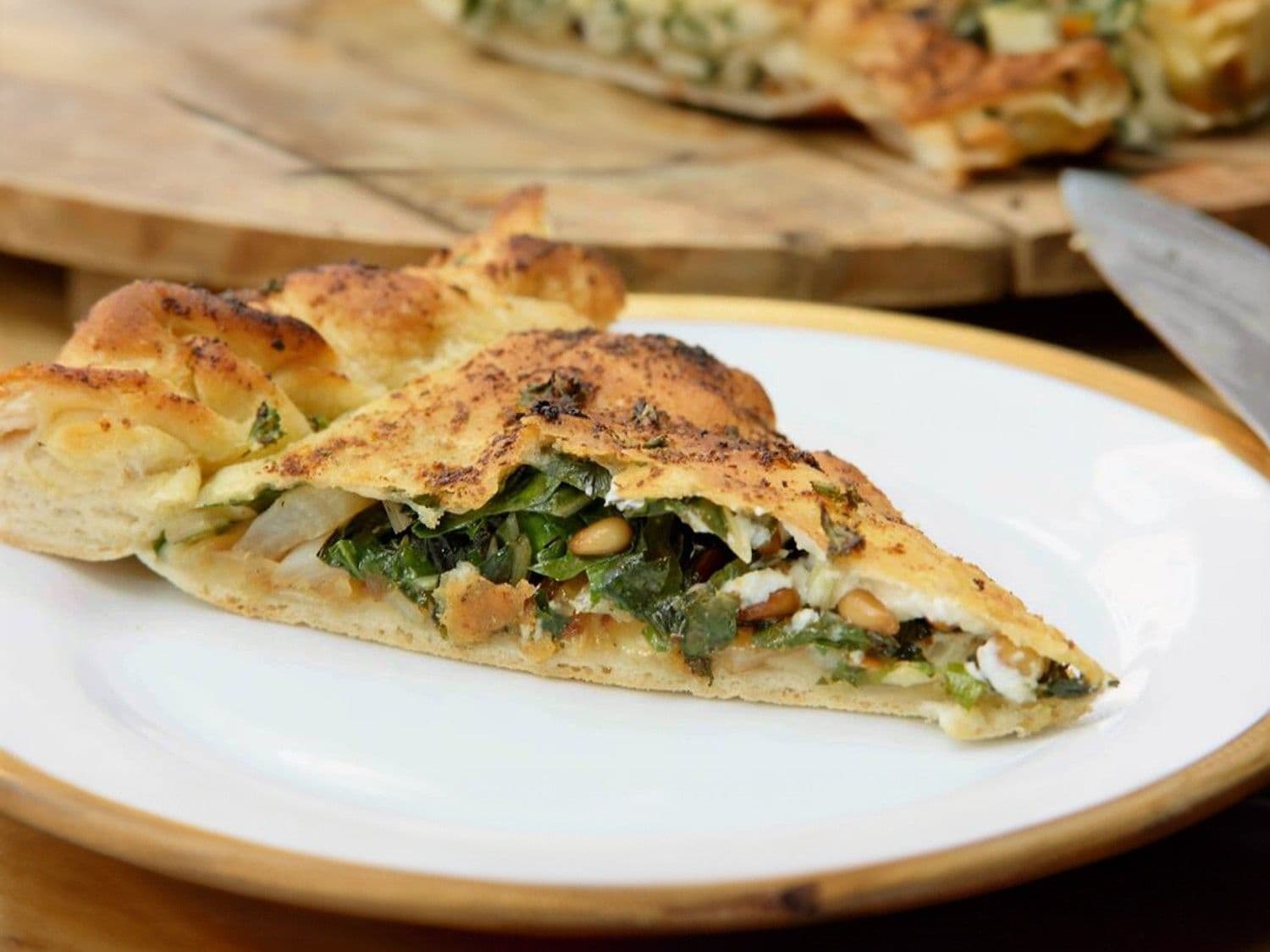 Pizza met gebakken ui, warmoes, feta en pijnboompitten