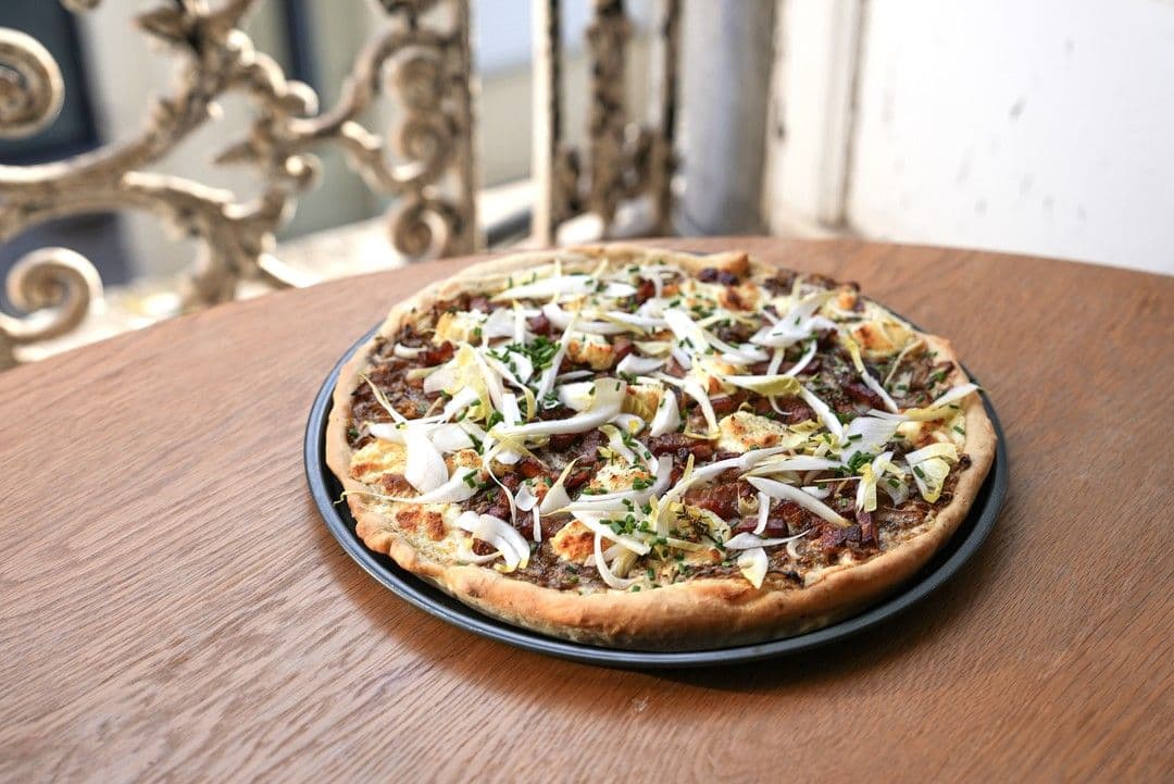 Tarte flambée met gekarameliseerd witloof, gerookt spek en geitenkaas