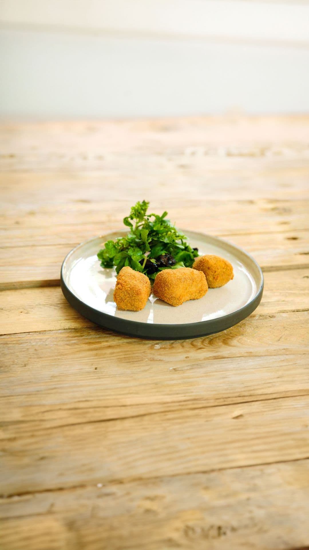 Vleeskroketje van konijn en een salade met pruimen