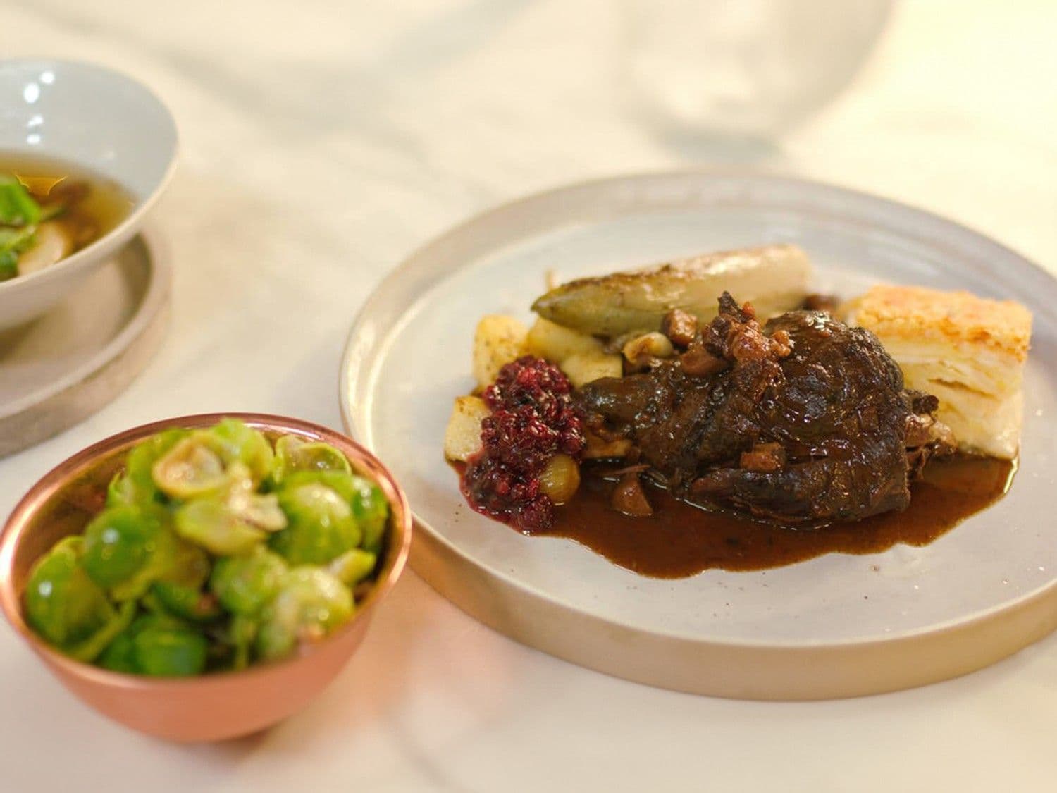 Stoverij van haas met knolselder-aardappelgratin en traditionele kerstgarnituren