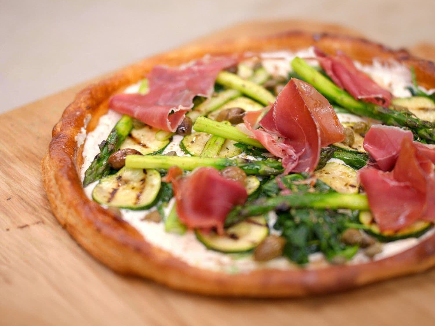 Bladerdeegpizza met groene groenten en ham