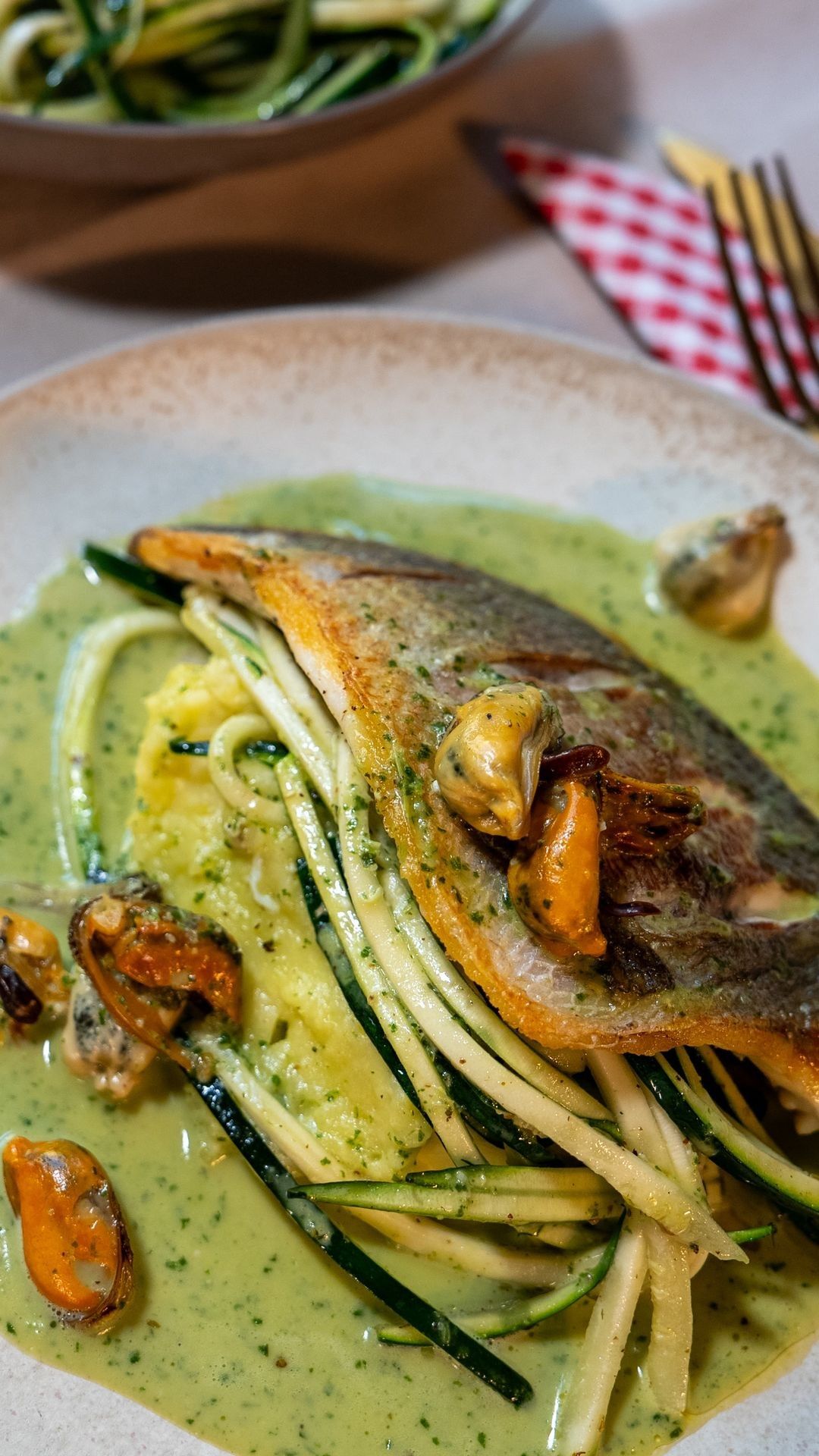 Gebakken dorade met mosselen, pestosaus, puree en courgette