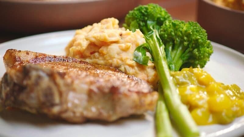 Varkenskotelet met wortelpuree, bimi en pickles