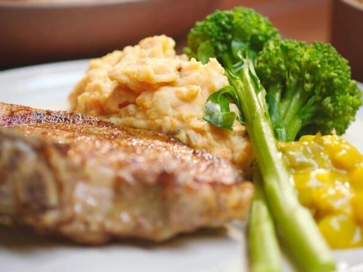 Varkenskotelet met wortelpuree, bimi en pickles