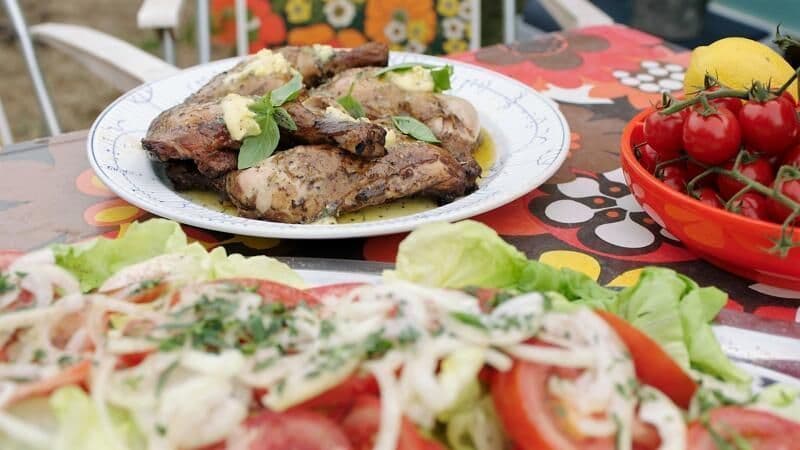 Kippenbillen op de bbq met peper-citroenboter, sla en tomaten