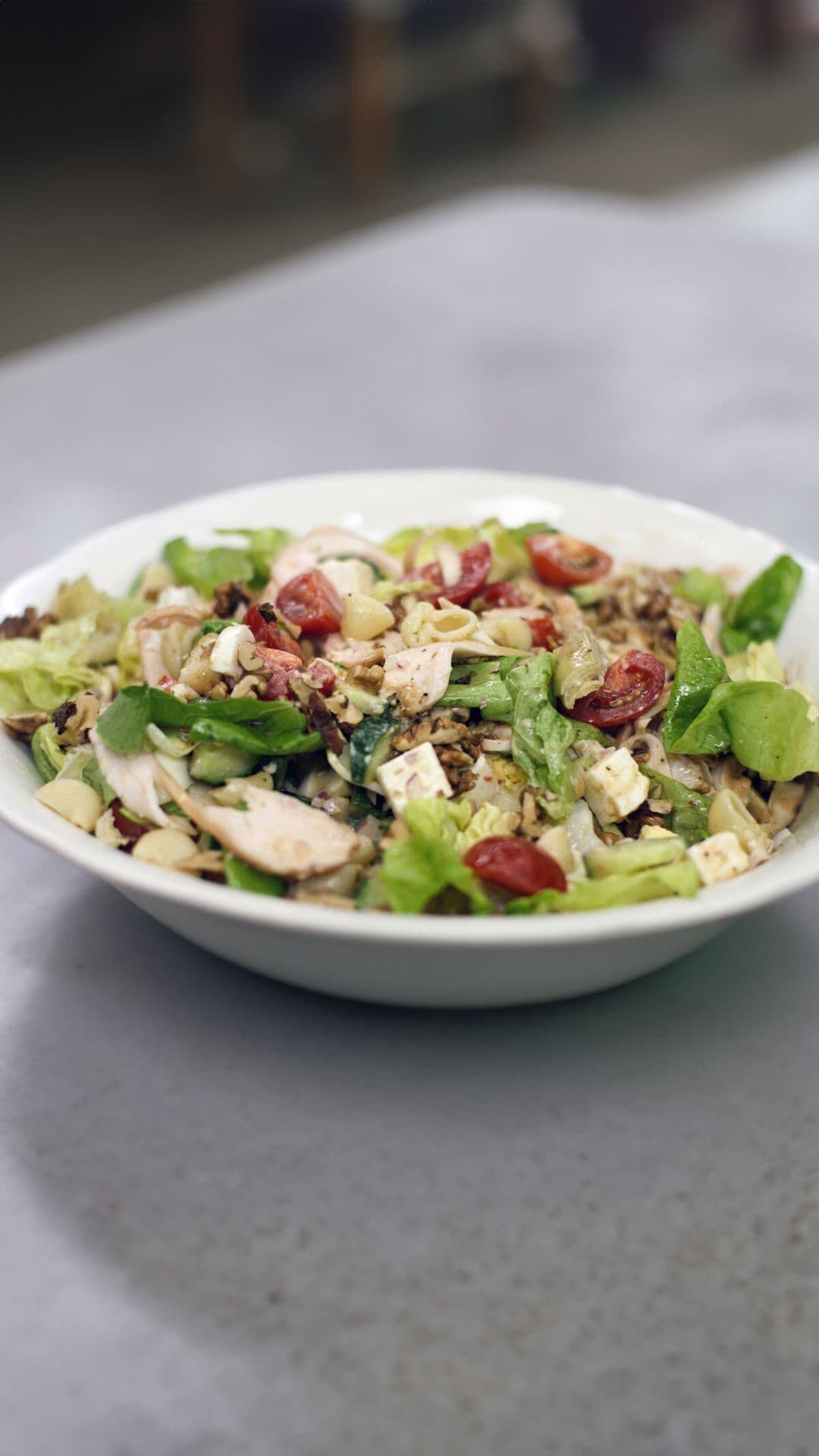 Frisse groentesalade met gerookte kip, feta en pasta