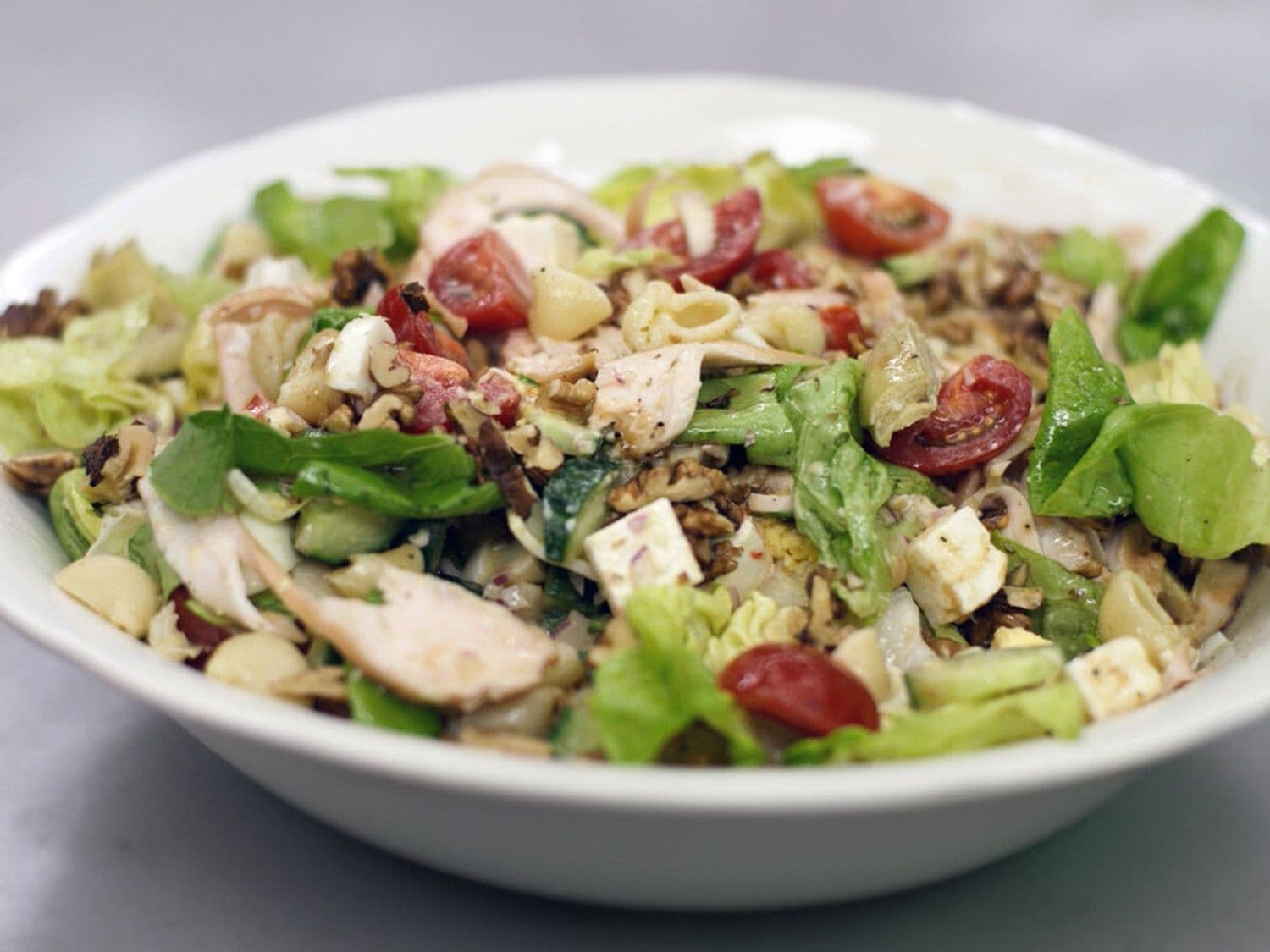 Frisse groentesalade met gerookte kip, feta en pasta