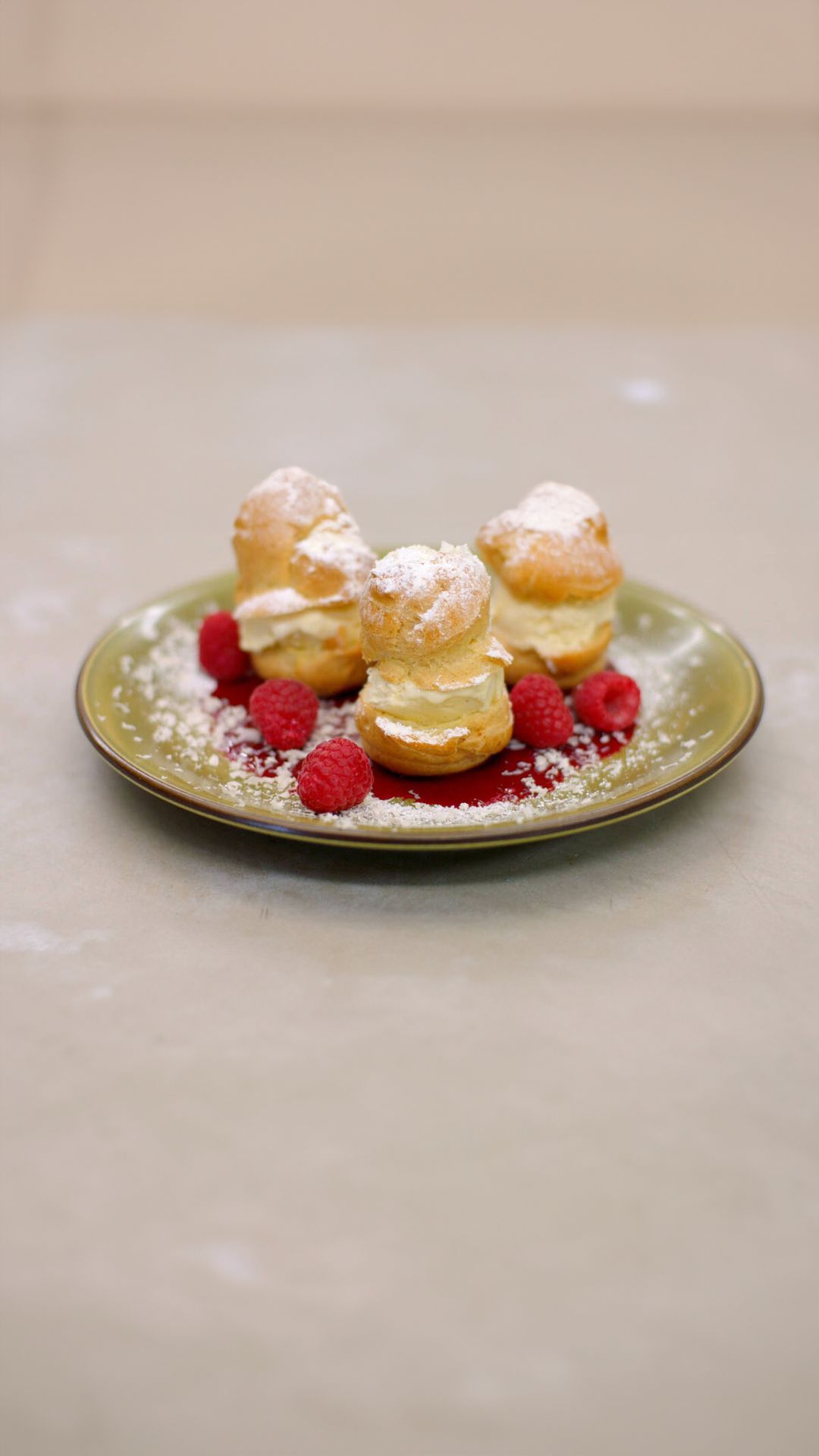 Profiteroles met frambozencoulis, roomijs en witte chocolade