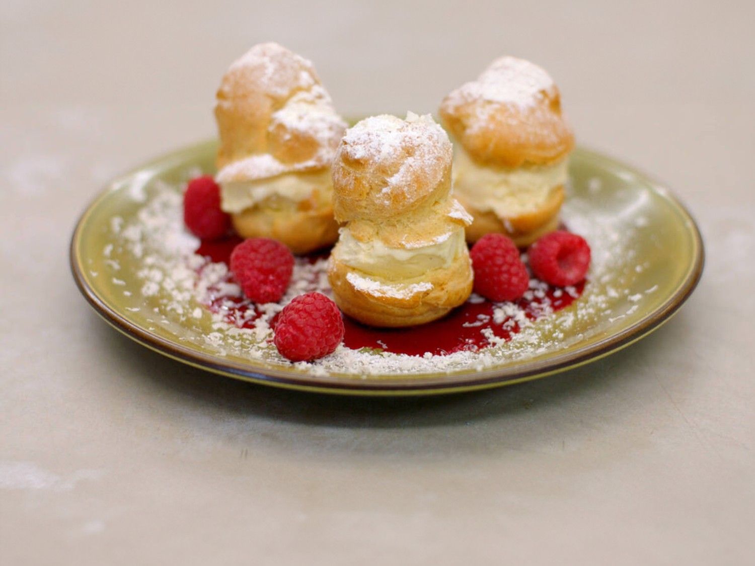 Profiteroles met frambozencoulis, roomijs en witte chocolade