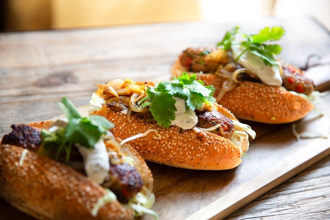 Köfte hotdog met tahinsaus en gebakken ui