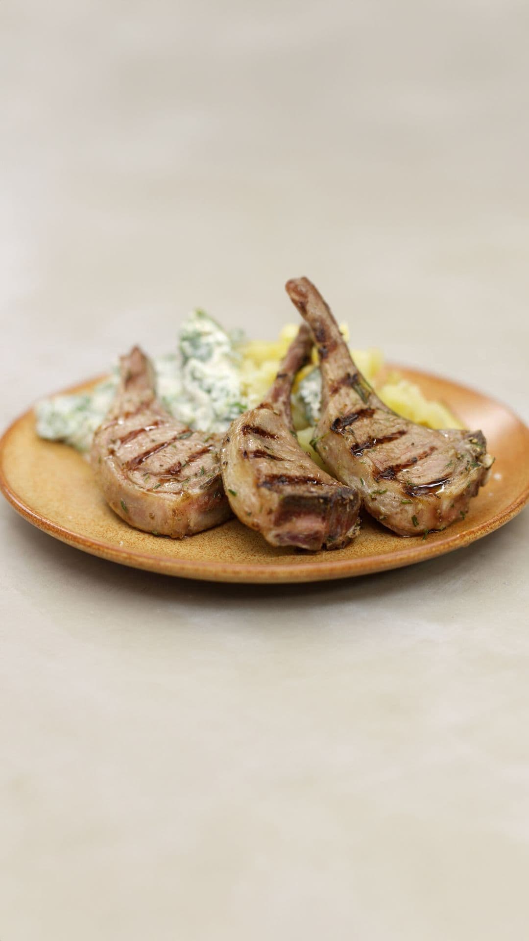 Gegrilde lamskoteletjes, gepofte aardappel  en venkeltzatziki