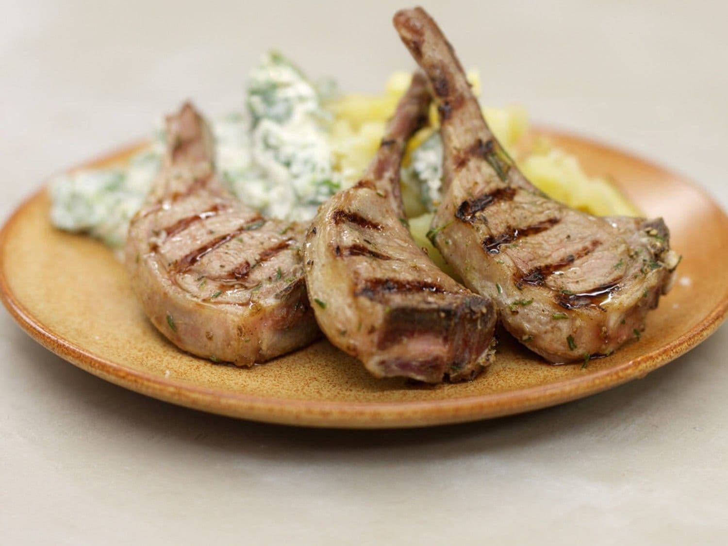 Gegrilde lamskoteletjes, gepofte aardappel  en venkeltzatziki