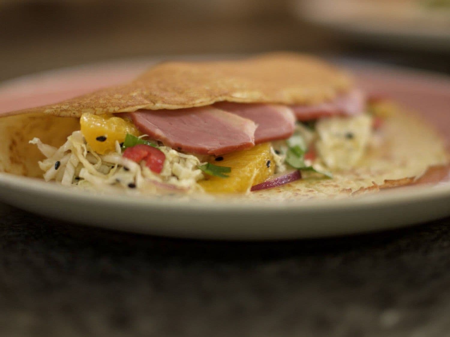 Koolsalade, sinaasappel en eendenborst in een polentapannenkoek