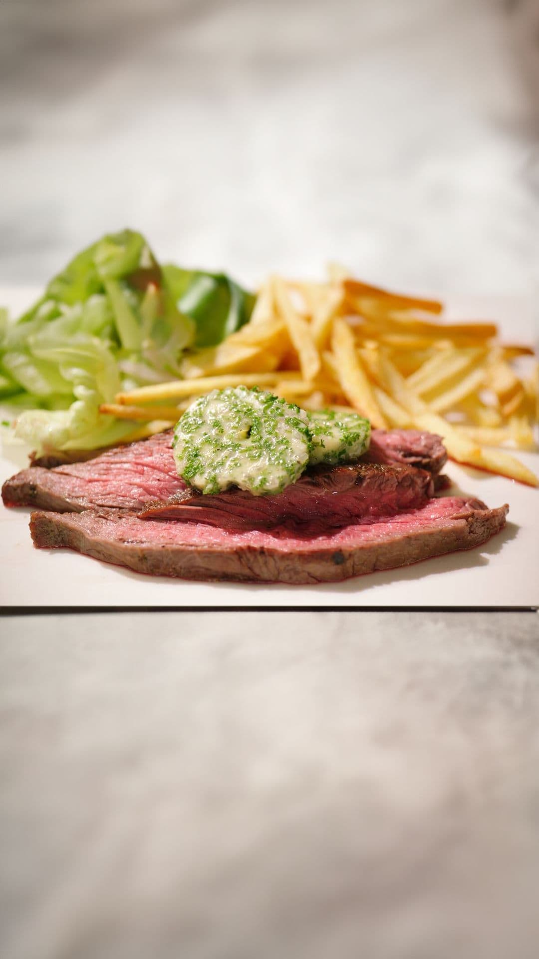 Gegrilde flankbiefstuk met hofmeesterboter, verse frieten en kropsla