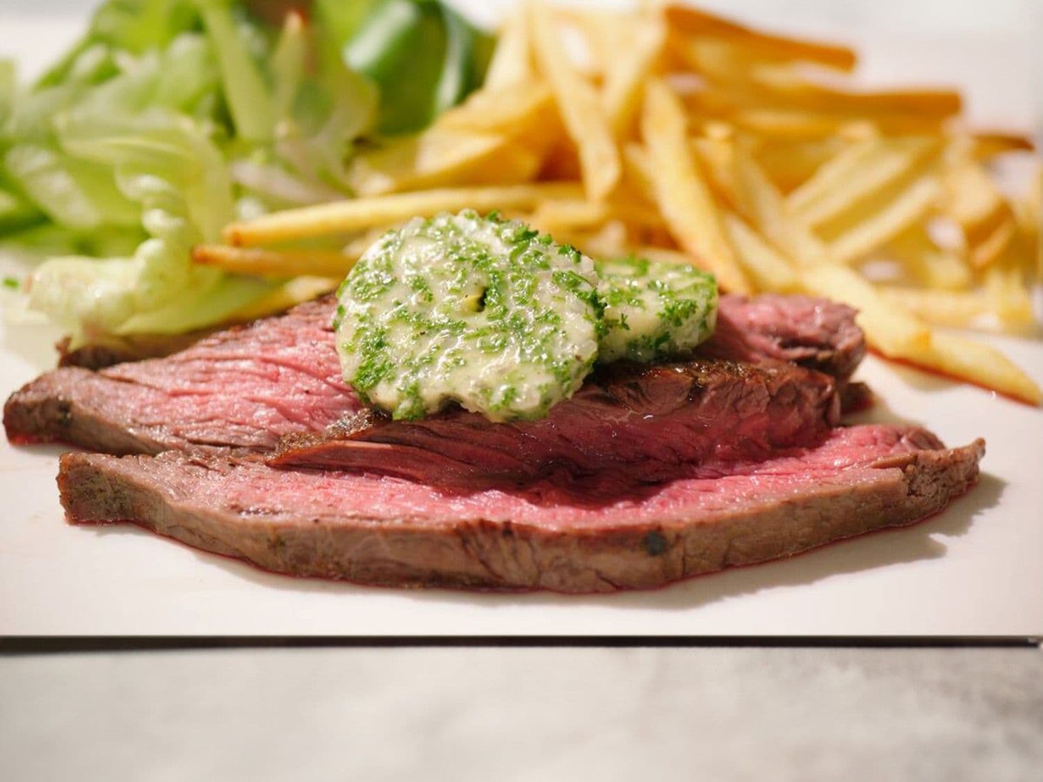 Gegrilde flankbiefstuk met hofmeesterboter, verse frieten en kropsla