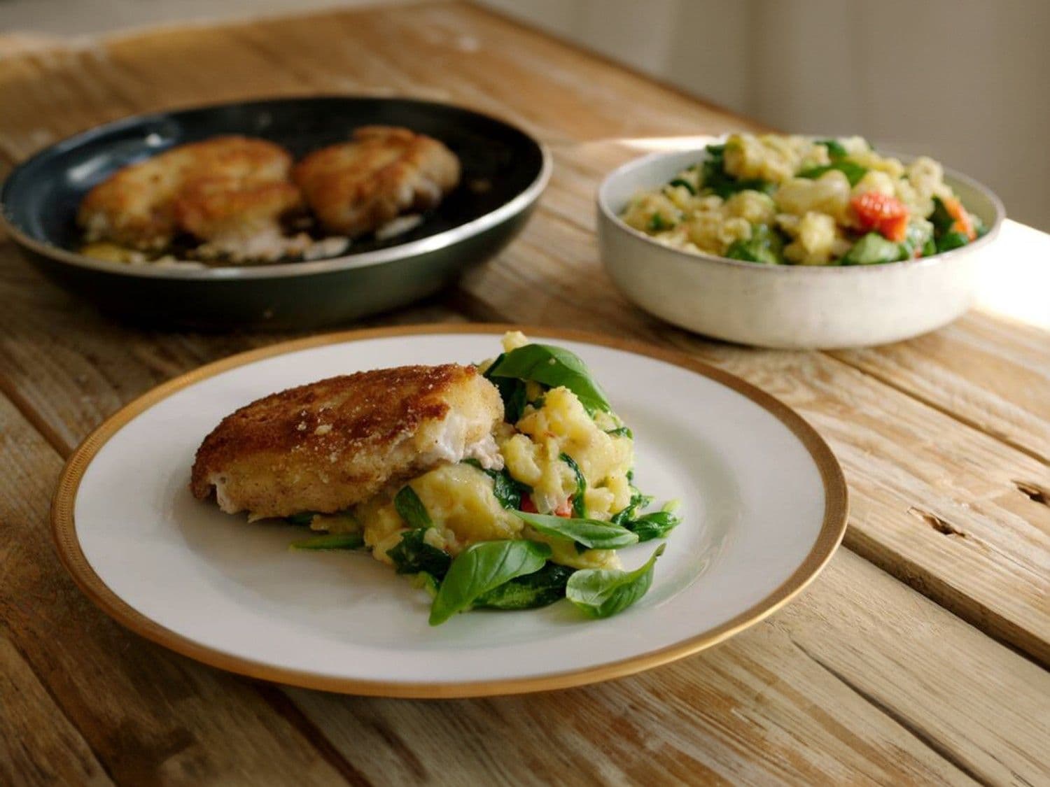 Zuiderse cordon bleu met geplette aardappel, zongedroogde tomaten en veldsla