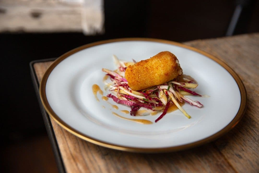 Kroket van geitenkaas en witloofsalade met radicchio en honingvinaigrette