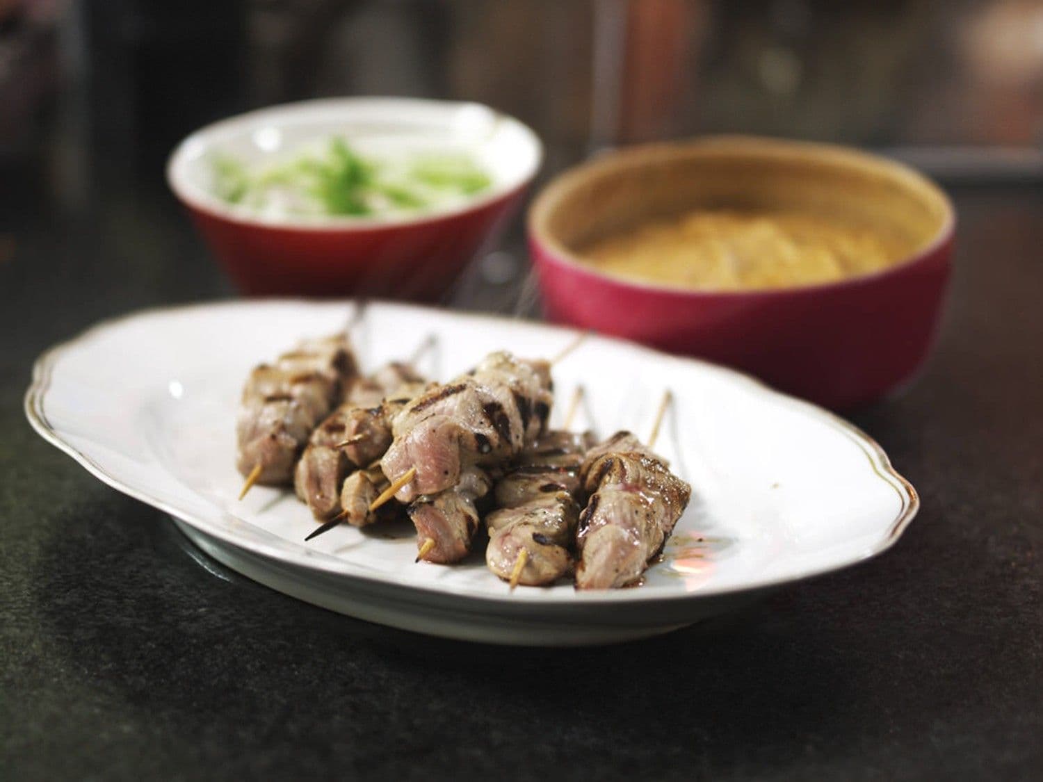 Satés van varkensvlees met pindasaus en komkommersalade