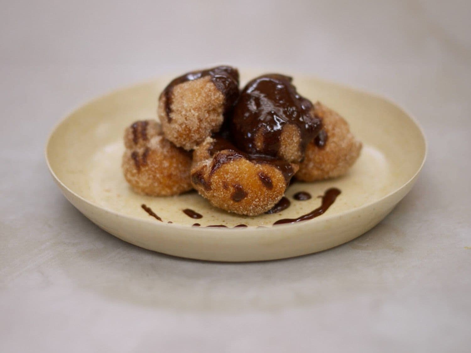 Gefrituurde soezen met kaneelsuiker en chocoladesaus