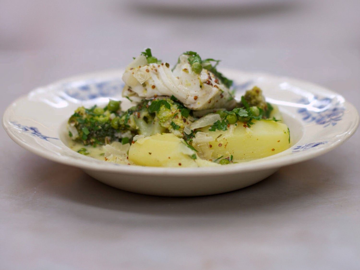 Schelvis met romige broccoli, erwten en aardappelen