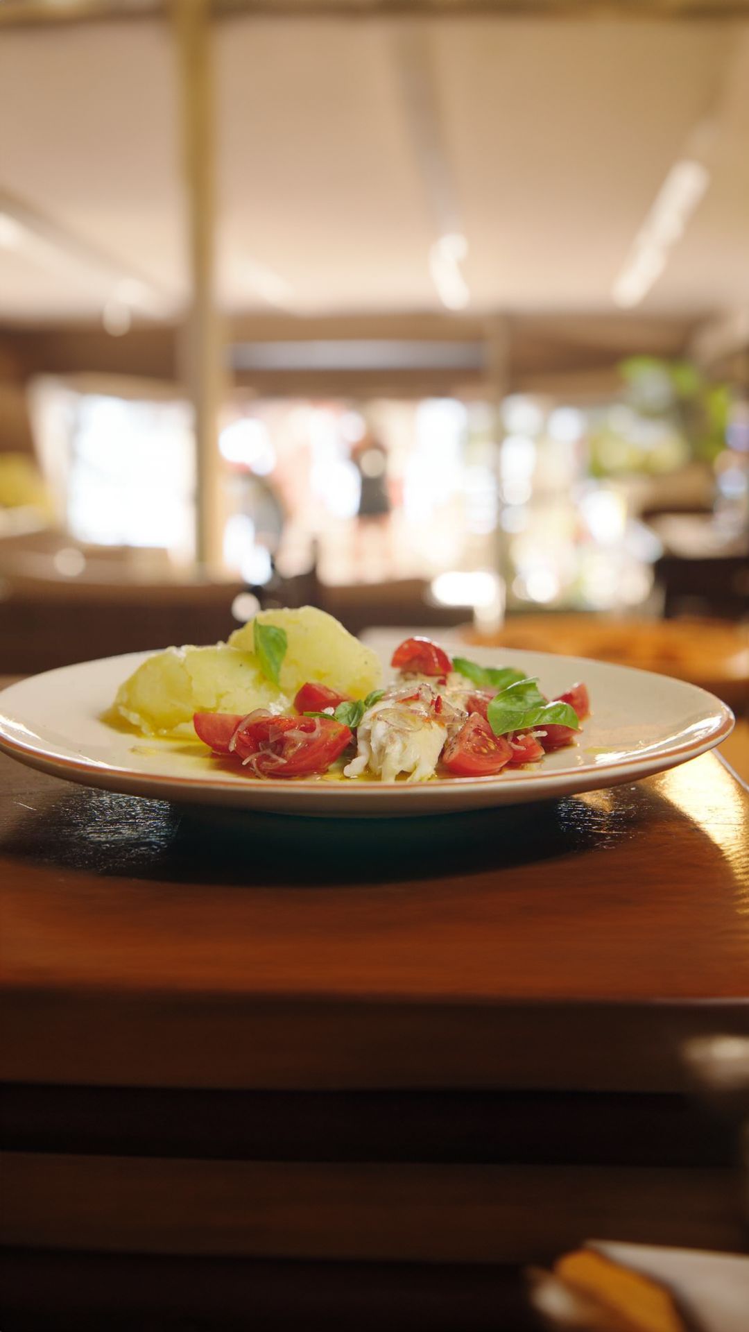 Zeebaars met geplette aardappel en tomaten