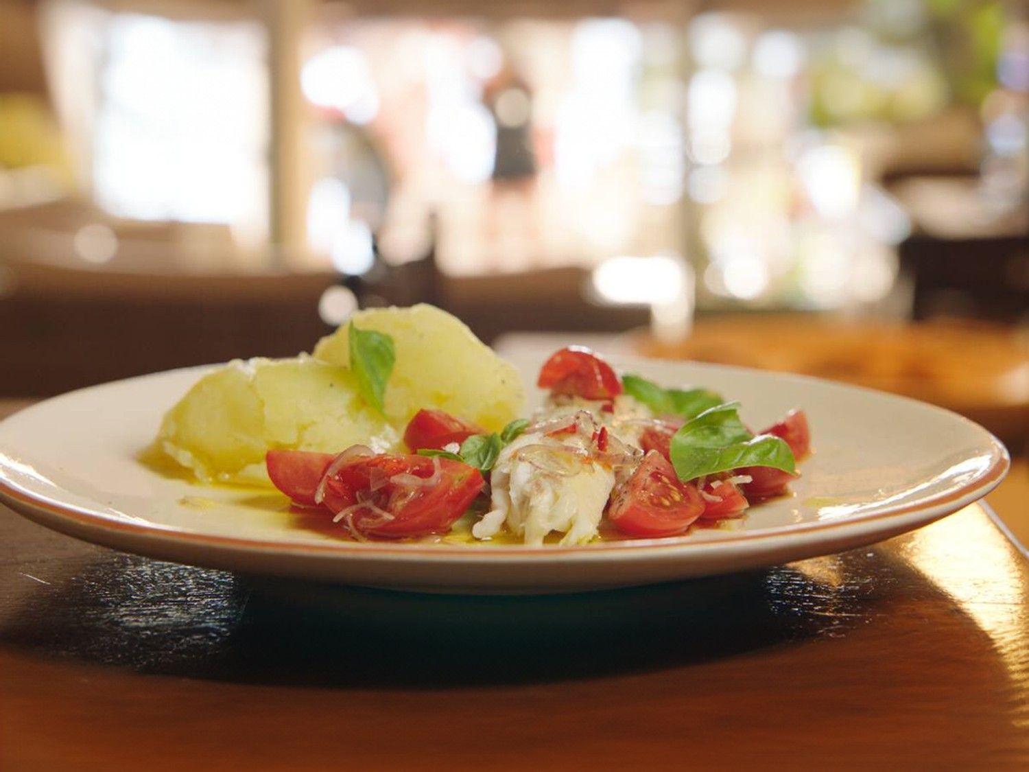 Zeebaars met geplette aardappel en tomaten