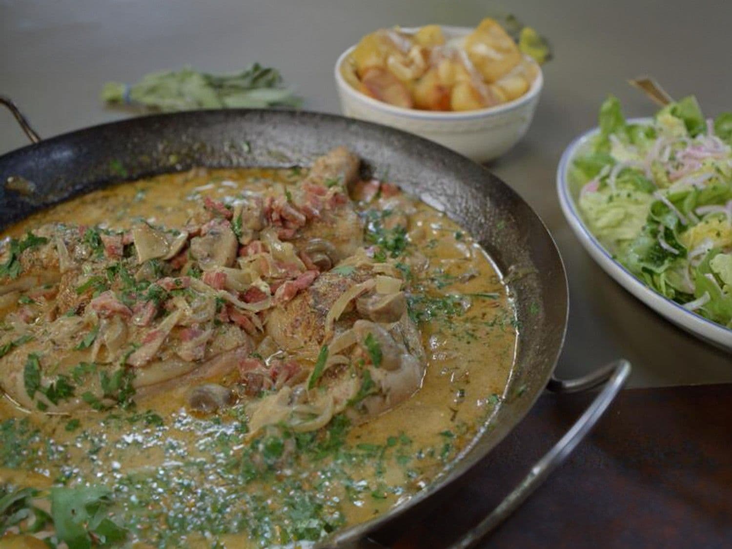 Stoofpot van kip met pancetta en champignons, gebakken aardappelen en kropsla