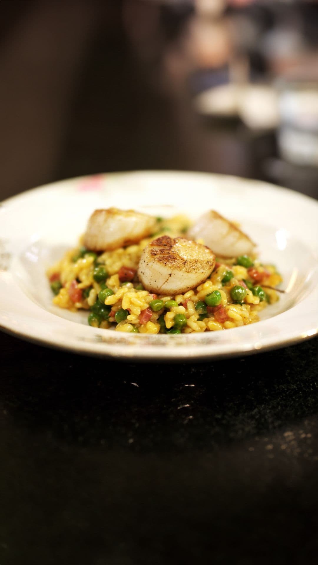 Sint-jakobsnootjes en risotto met erwtjes, chorizo en munt