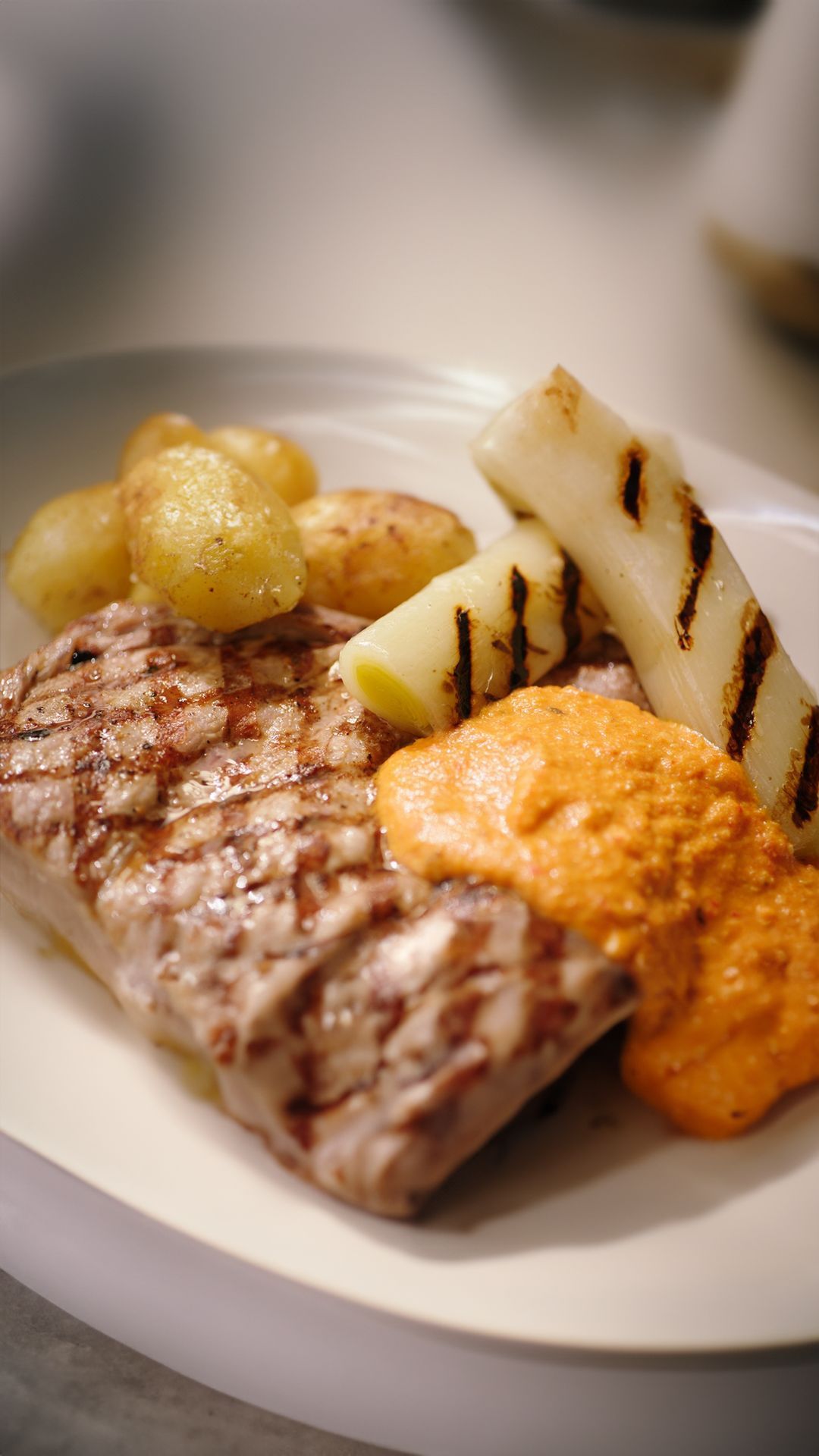 Kalfskotelet romesco met gebraiseerde prei en ratte-aardappelen